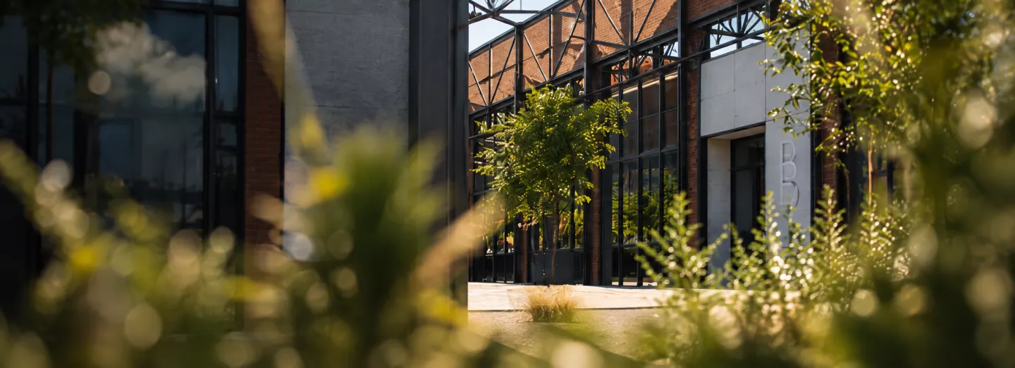 Entrée industrielle encadrée de verdure